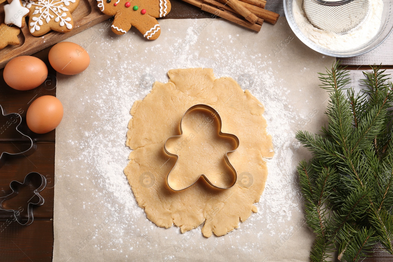 Photo of Making Christmas cookies. Flat lay composition with ingredients and raw dough on wooden table