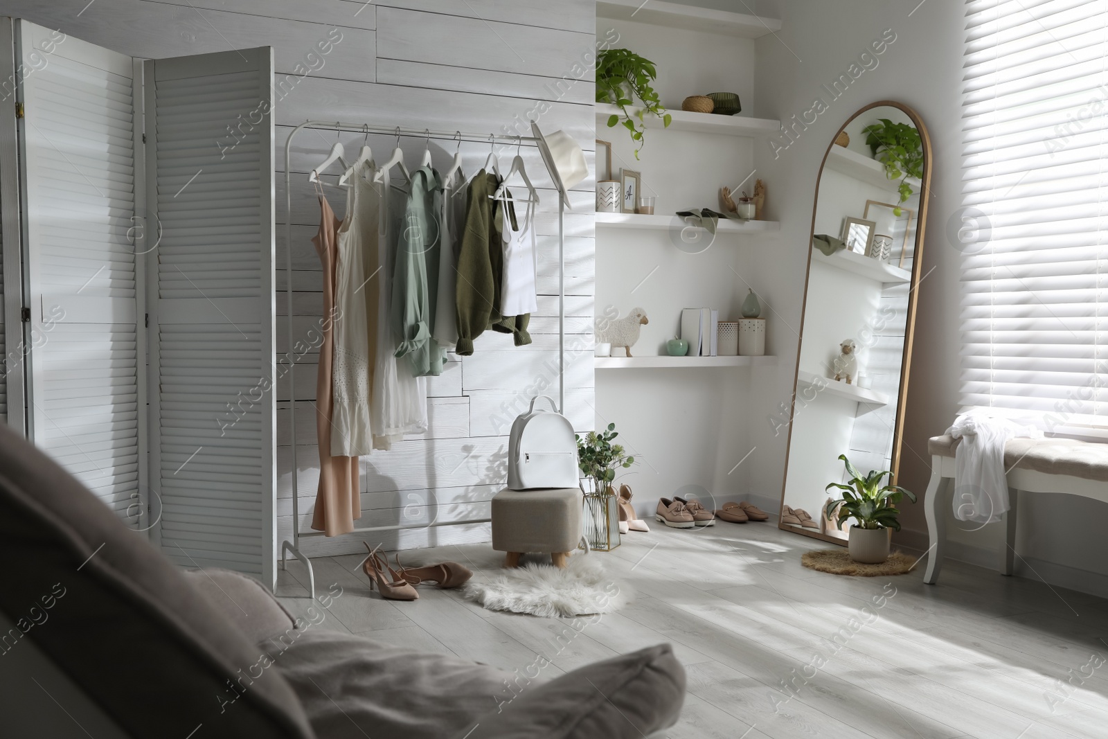 Photo of Rack with different stylish clothes, shoes and decorative elements in dressing room. Interior design