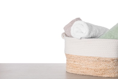 Photo of Soft towels in wicker basket on white background