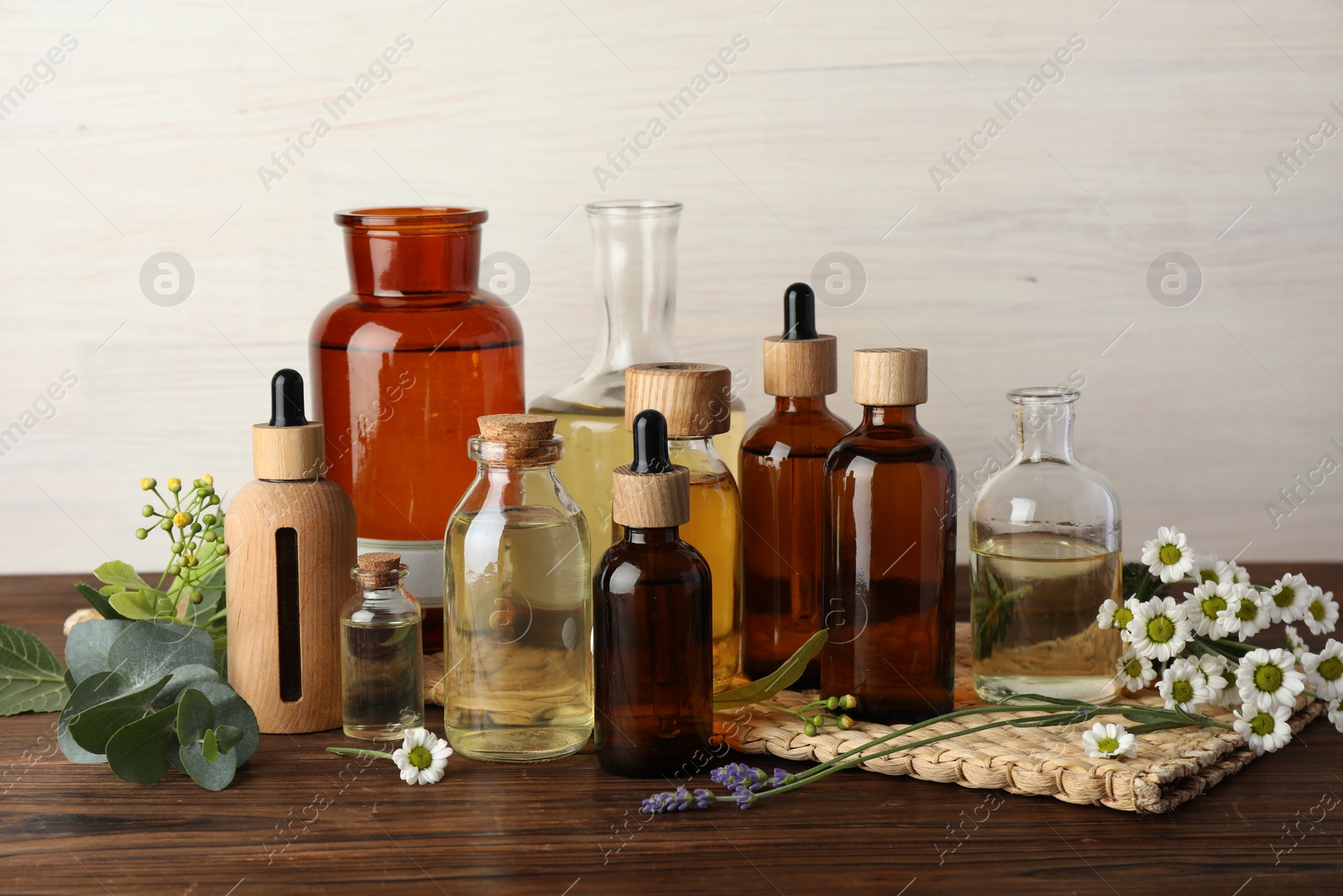 Photo of Aromatherapy. Different essential oils and flowers on wooden table