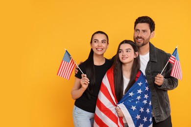 4th of July - Independence Day of USA. Happy family with American flags on yellow background, space for text