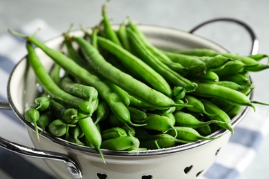 Photo of Fresh green beans in colander, closeup view