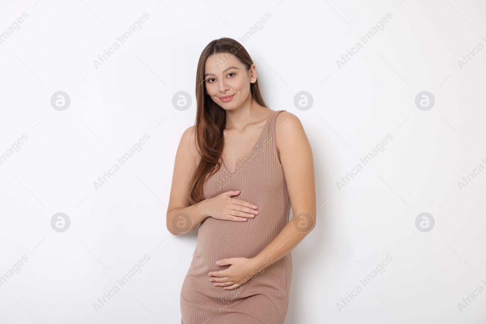 Photo of Beautiful pregnant woman in beige dress on white background