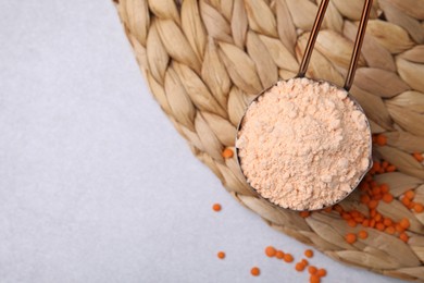 Photo of Organic lentil flour on wicker mat, flat lay. Space for text