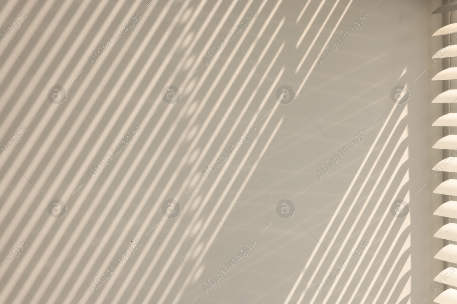 Photo of Shadow from window and blinds on beige wall indoors