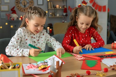 Cute little children making beautiful Christmas greeting cards at home