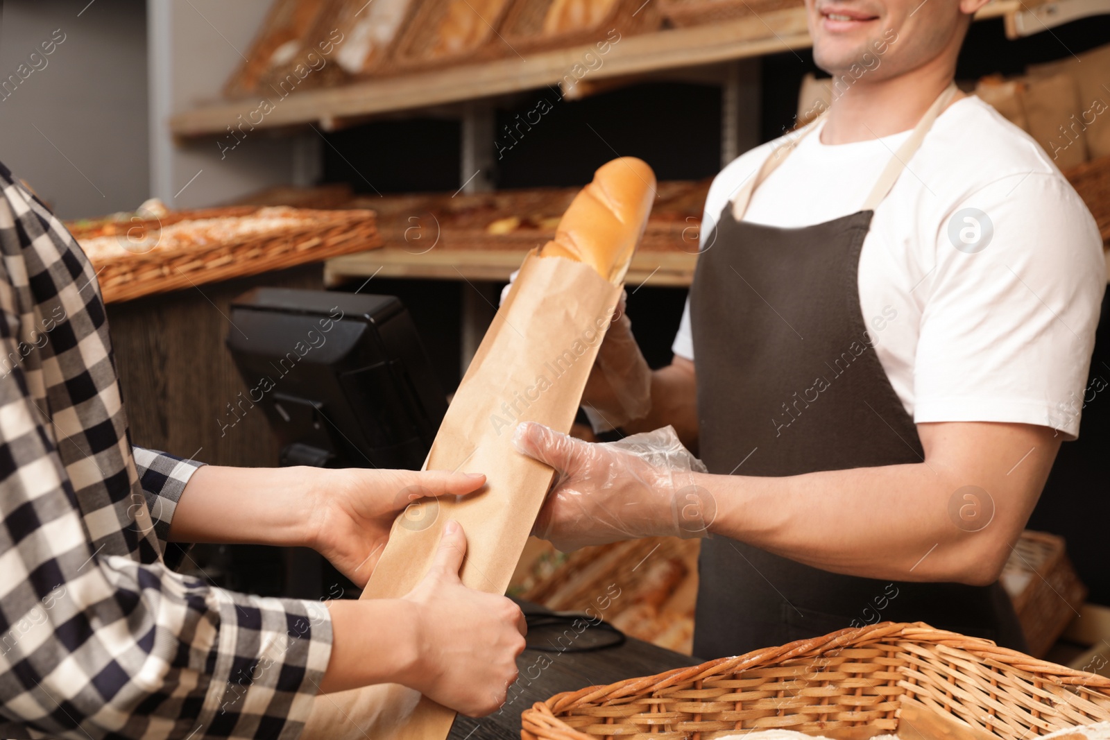 Photo of Woman buying fresh baguette in bakery shop, closeup