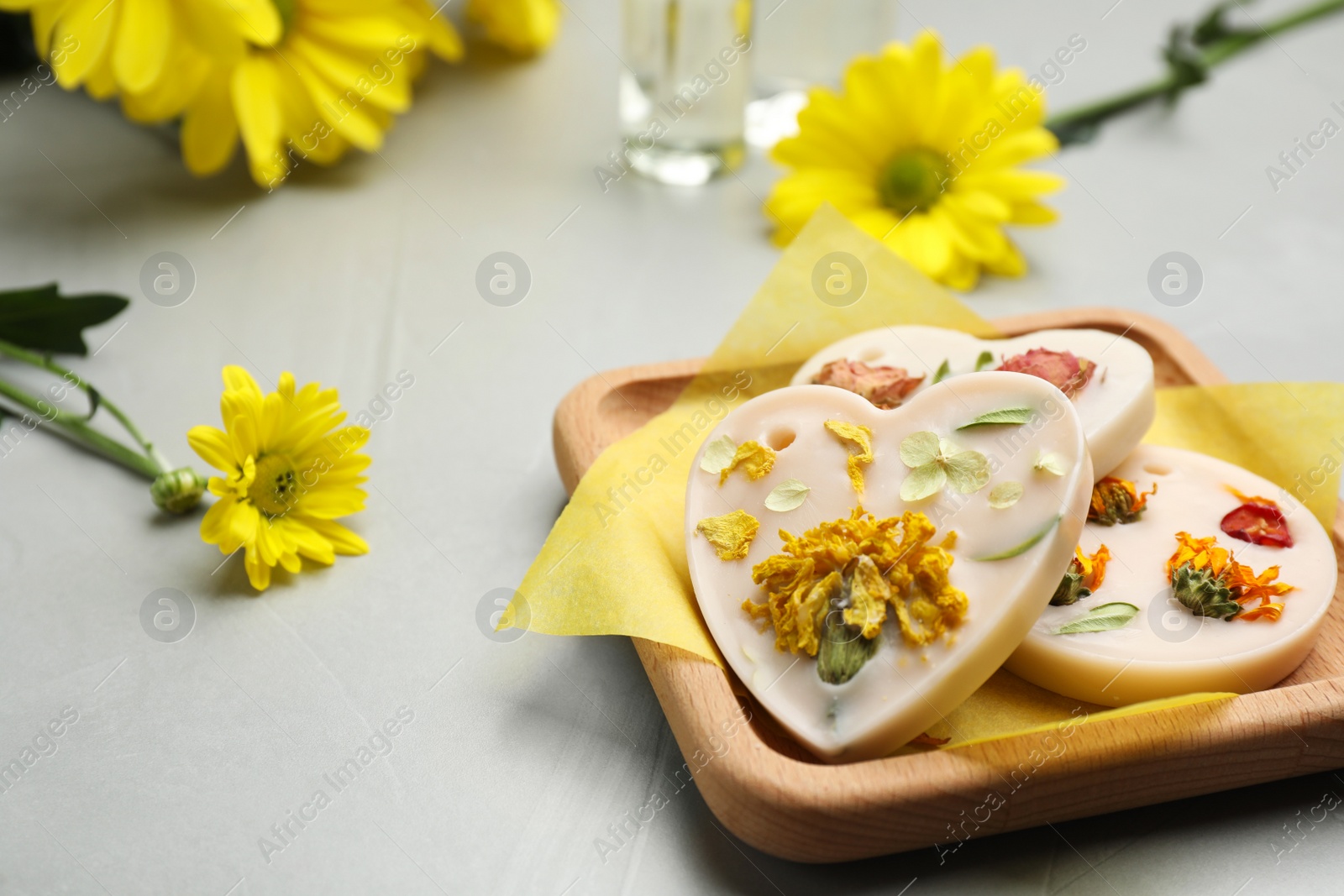 Photo of Scented sachets and flowers on light grey table