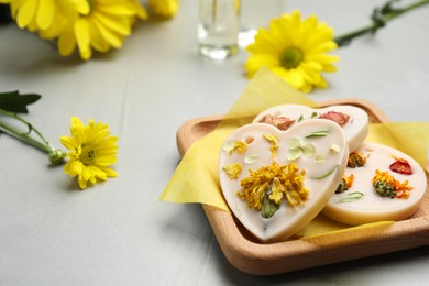 Photo of Scented sachets and flowers on light grey table