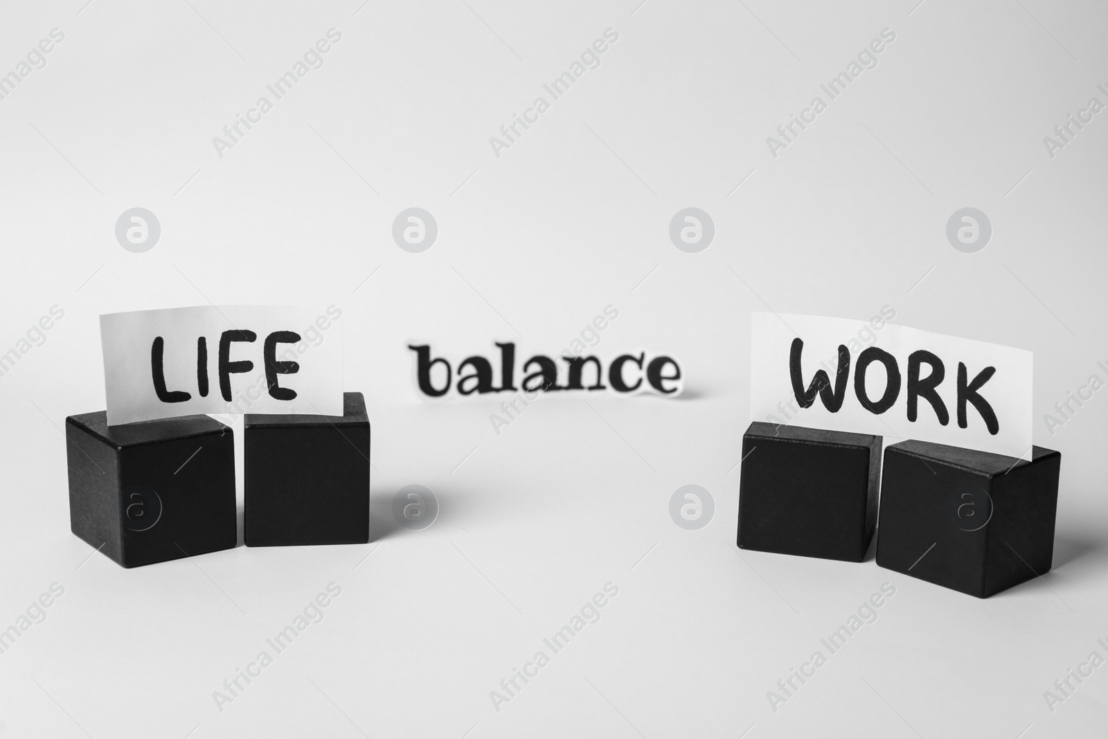 Photo of Black cubes and paper pieces with words Life, Balance, Work on white background