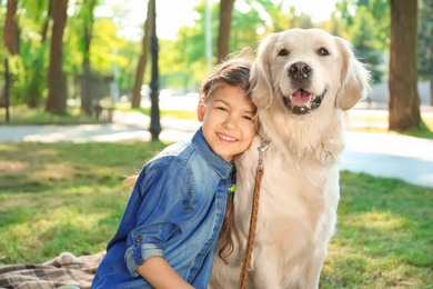 Photo of Cute little child with his pet in green park