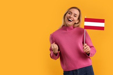 Image of Happy young woman with flag of Austria on yellow background