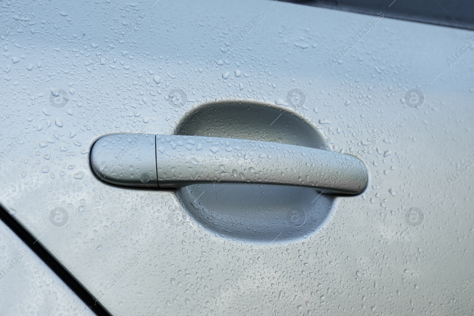 Photo of Closeup view of car door handle with water drops