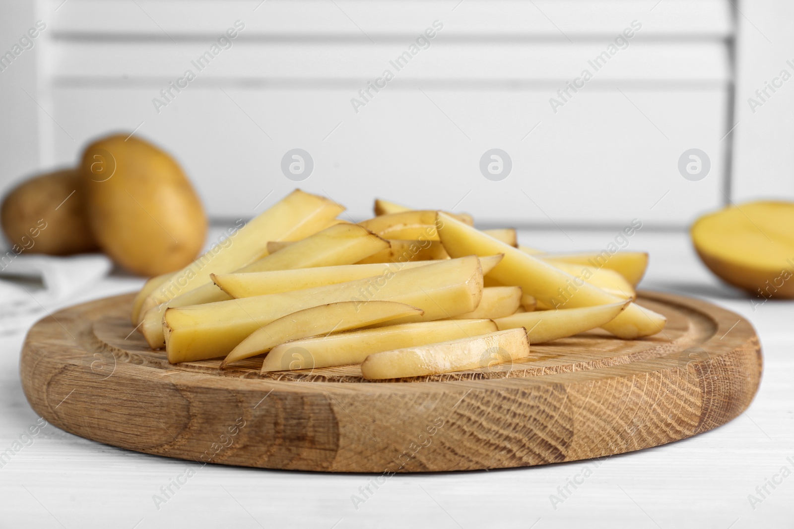 Photo of Cut raw potatoes on white table, closeup