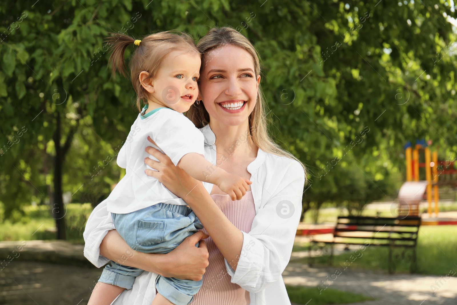 Photo of Happy mother with her daughter walking in park. Space for text