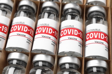 Glass vials with COVID-19 vaccine in package, closeup