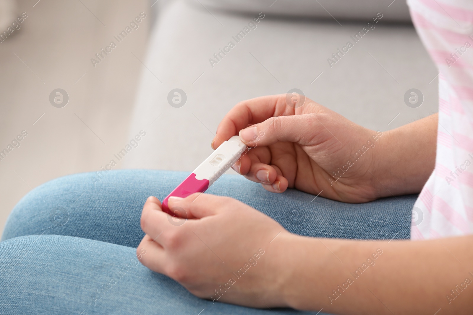 Photo of Young woman with pregnancy test indoors, closeup. Gynecology and childbirth