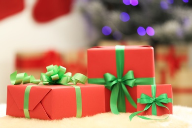 Photo of Christmas gifts on fuzzy rug against blurred background