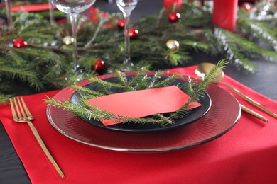 Elegant Christmas place setting with blank card and festive decor on table