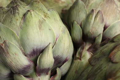 Photo of Fresh raw artichokes as background, closeup view