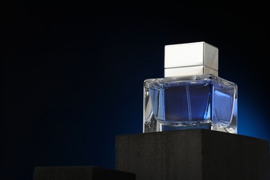 Luxury men`s perfume in bottle against dark background, space for text