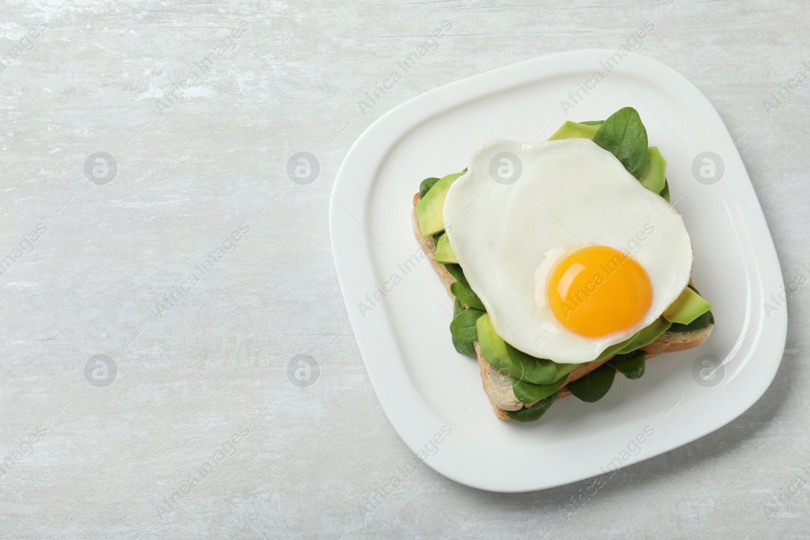 Photo of Delicious breakfast with fried egg served on table, top view. Space for text