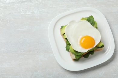 Photo of Delicious breakfast with fried egg served on table, top view. Space for text