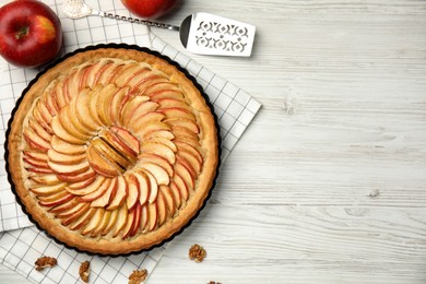 Flat lay composition with delicious homemade apple tart on white wooden table. Space for text