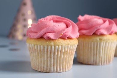 Photo of Delicious cupcakes with bright cream on light background, closeup