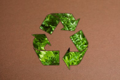 Recycling symbol made of green leaves on kraft paper