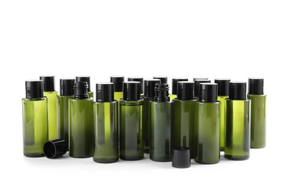 Mini bottles with cosmetic products on white background