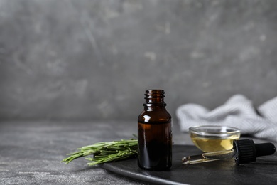 Composition with essential oil and rosemary on table. Space for text