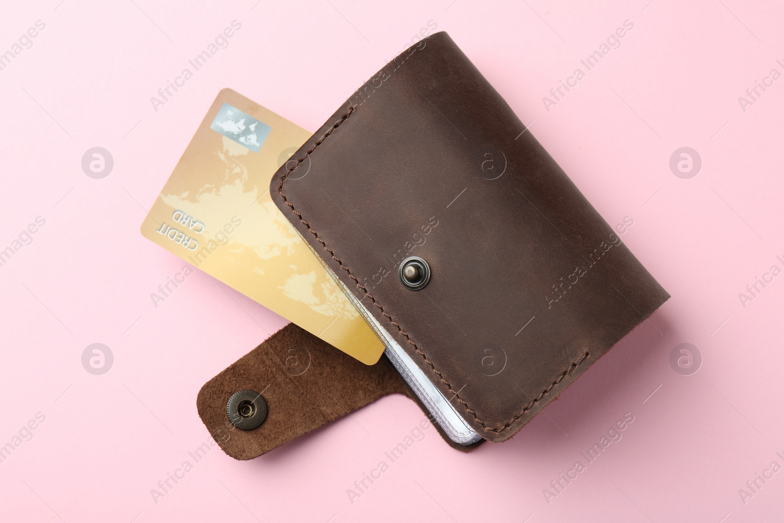 Photo of Leather card holder with credit card on pink background, top view