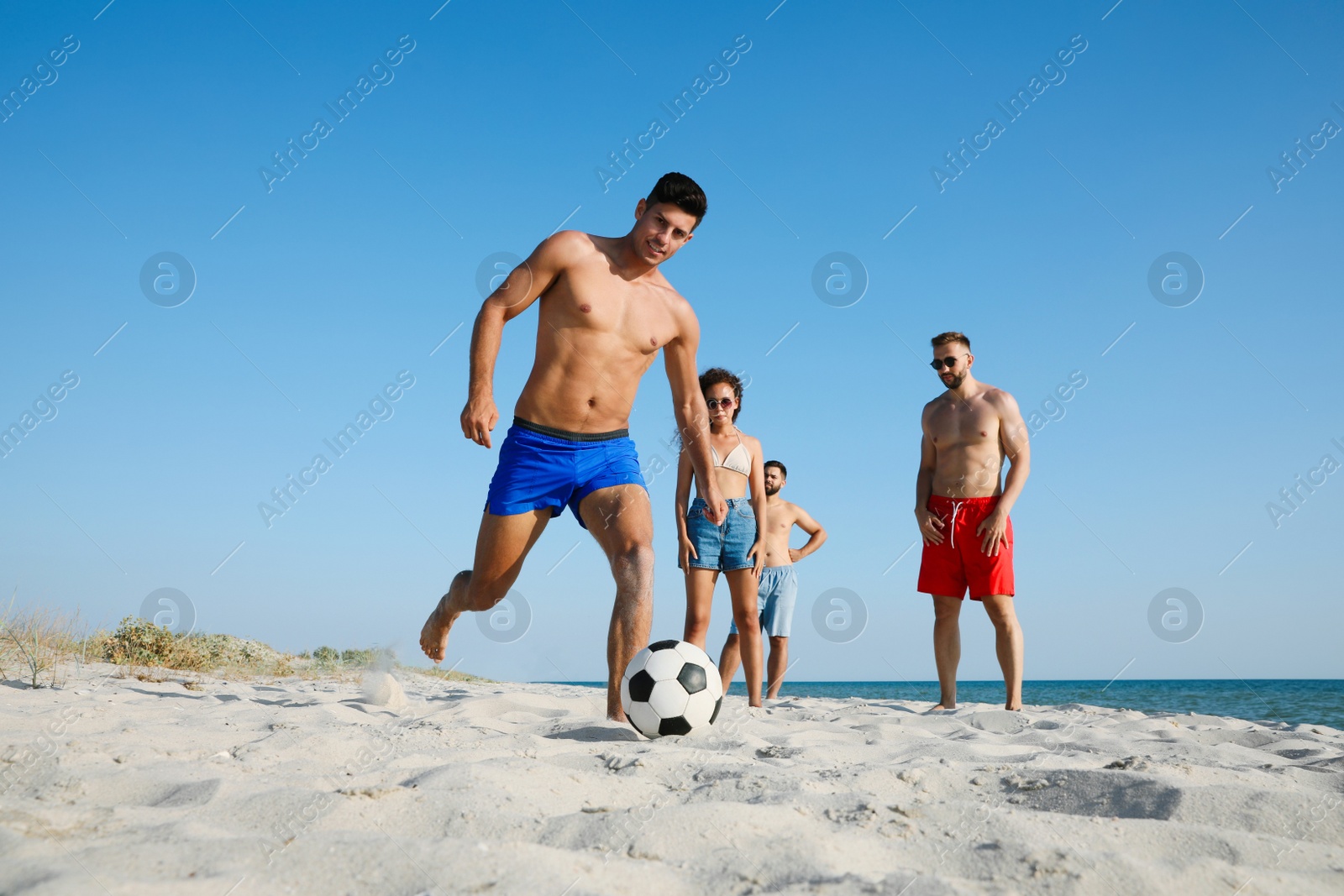 Photo of Group of friends playing football on beach