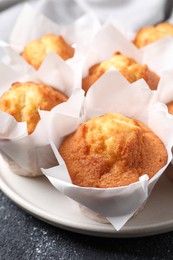 Delicious sweet muffins on black textured table, closeup