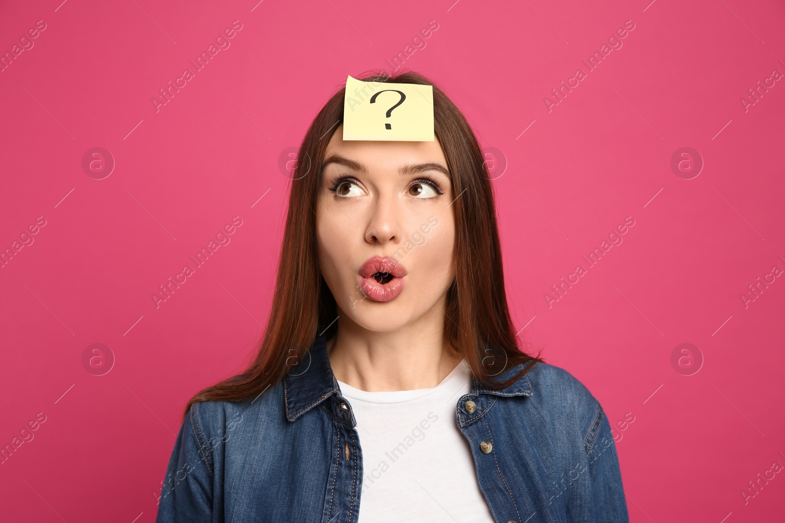 Photo of Emotional woman with question mark sticker on forehead against pink background