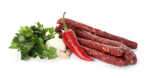 Photo of Thin dry smoked sausages and different spices isolated on white