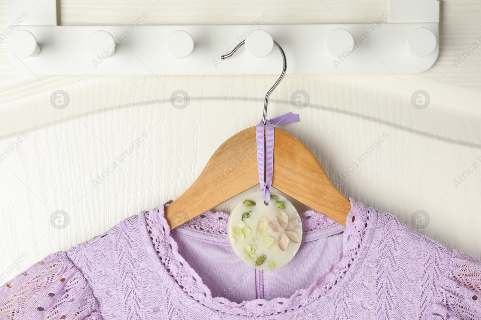 Photo of Scented sachet with flowers and stylish clothes on hanger