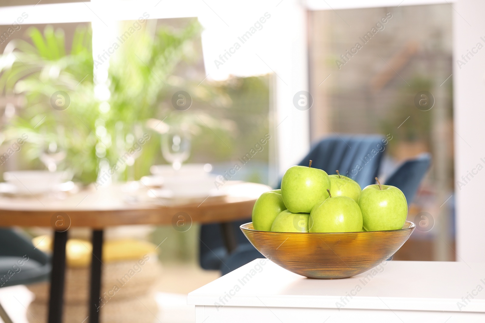 Photo of Bowl with sweet green apples on commode in room, space for text