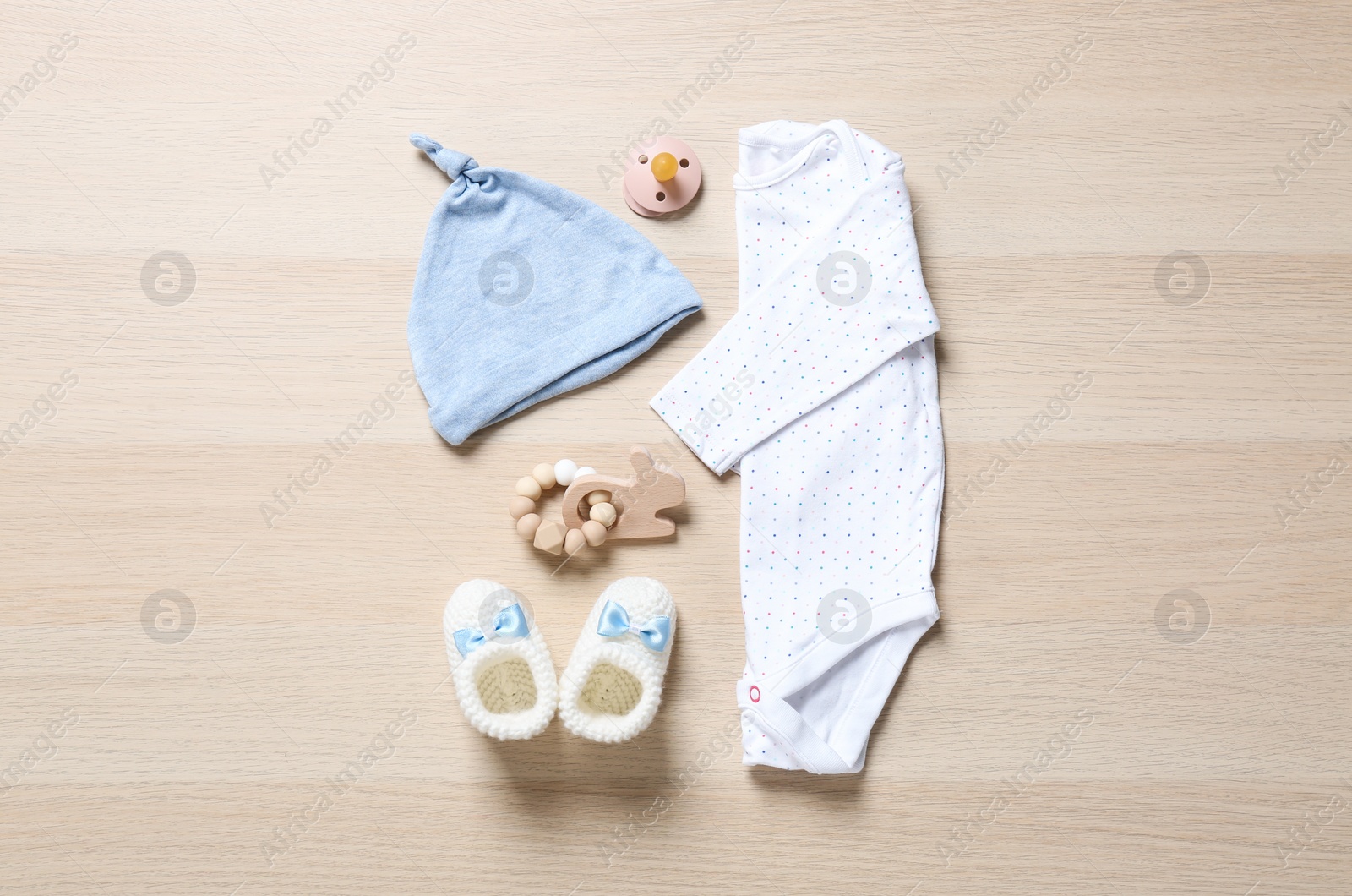 Photo of Flat lay composition with cute baby clothes on wooden background