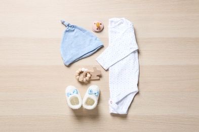 Photo of Flat lay composition with cute baby clothes on wooden background