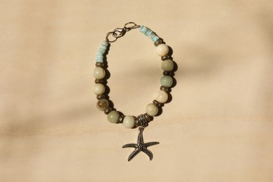 Photo of Beautiful bracelet with different gemstones on beige background, top view