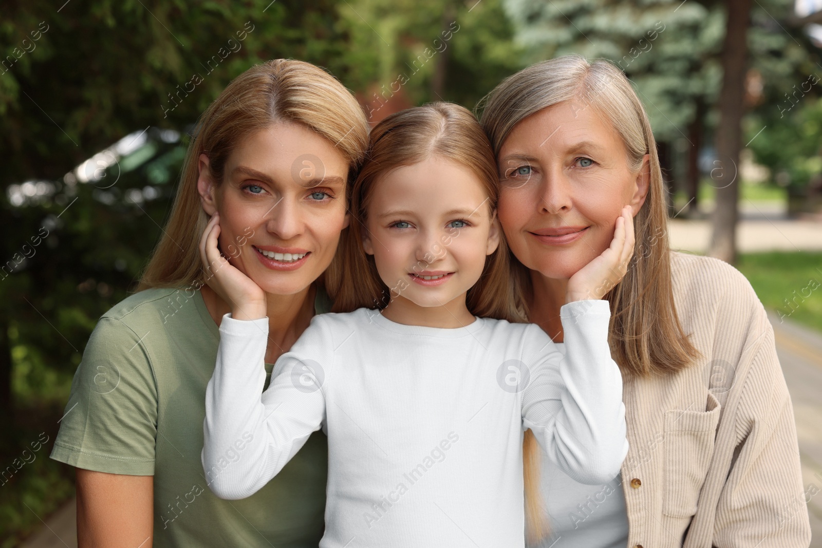 Photo of Three generations. Happy grandmother, her daughter and granddaughter outdoors