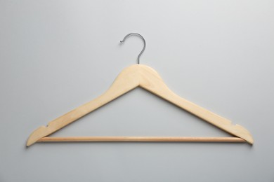 Wooden hanger on light gray background, top view