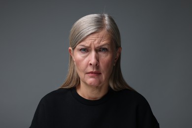 Photo of Personality concept. Portrait of emotional woman on gray background