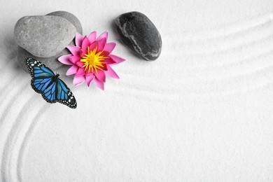 Image of Beautiful butterfly, flower and stones on white sand with pattern, flat lay. Zen concept