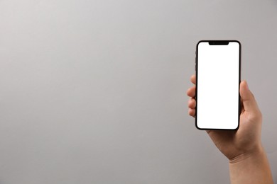 Photo of Man with smartphone on grey background, top view. Space for text