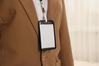 Photo of Woman with blank badge indoors, closeup. Space for text