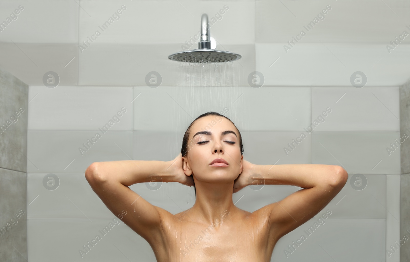 Photo of Beautiful young woman taking shower in spa center