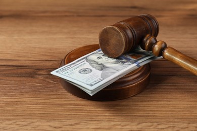 Judge's gavel and money on wooden table